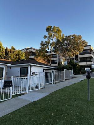 The outside view right by the meter parking. There is a handicap ramp, and stairs to the right that lead to the front door entrance.