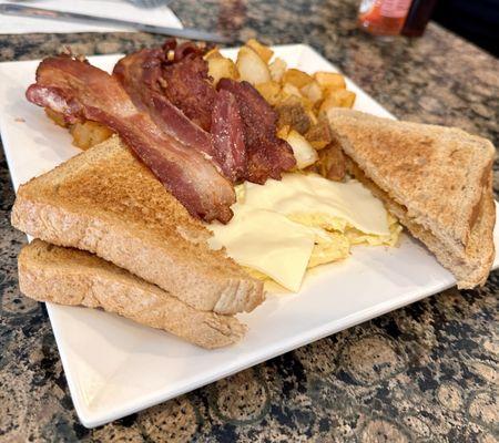 Scrambled eggs, toast, bacon, home fries