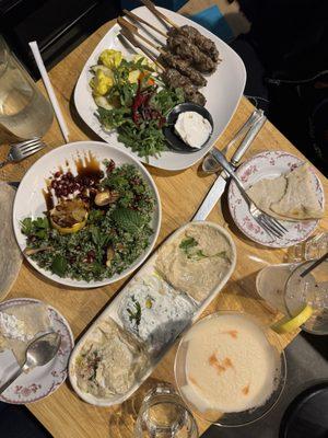 Lakhma trio dip with house flatbread, Grilled kufta, and special pomegranate tabouleh with pomegranate molasses.