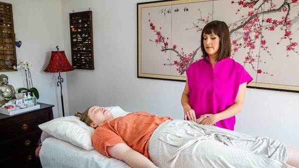 Nicole McLaughlin performing pulse diagnosis on a patient