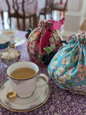 Teapots with peach bellini tea and cucumber mint white tea. Cute tea cozies!