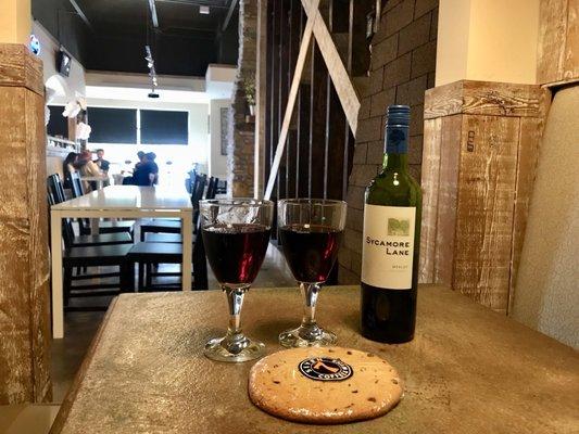 A bottle of Merlot and a giant cookie.