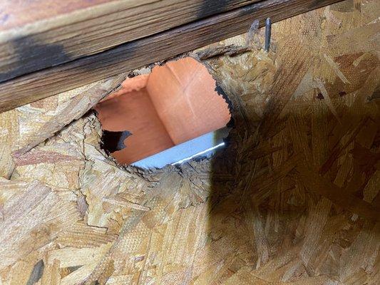 Squirrel damage in top of attic peak by gutter