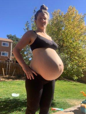 A very large pregnant woman who is managing to stand upright only because she got massaged by Emily Kollander every week.