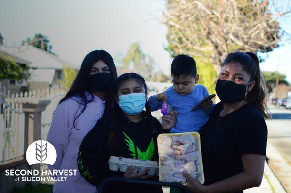 Norma and her family with some food from Second Harvest.