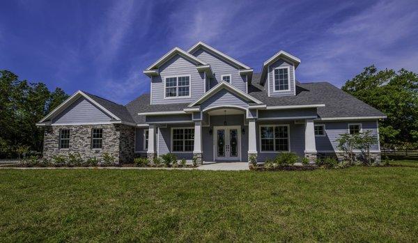 This two story custom designed home built by Rotunda Homes features Hardie-Board, cultured stone, and craftsman style pillars.