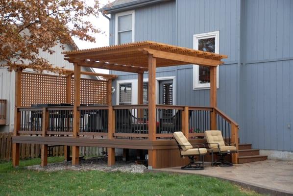 TimberTech Composite Decking, Composite 2x4 Handrail with Fortress - Square, Antique Bronze Balusters and an Oiled Cedar Pergola