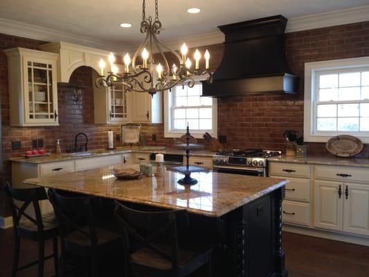 Gorgeous Kitchen Remodel with Off White Painted Cabinets with a Black Distressed Island and Hood.