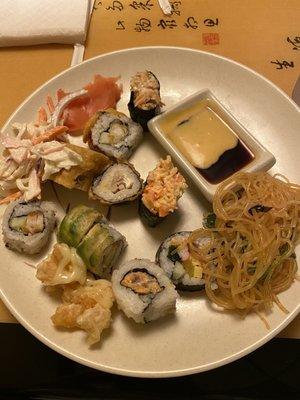 Variety of sushi, coconut shrimp, and seaweed salad.