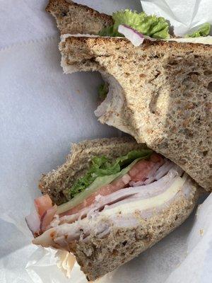 Turkey cheese on multigrain bread fresh onion lettuce tomato. Lots of veggies just the way I like it.