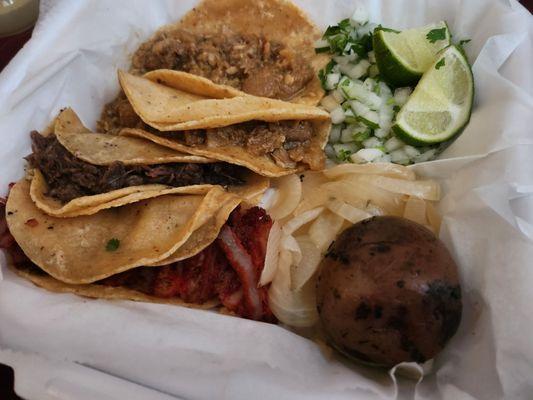 Chicharron tacos, one barbacoa taco, trompo taco, side of cilantro and onions, grilled onions, and a small cooked potato.