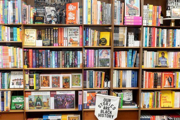 The beautiful, teakwood bookshelf displays HBCU authors, best sellers, puzzles, cookbooks and Caribbean Mocktails.