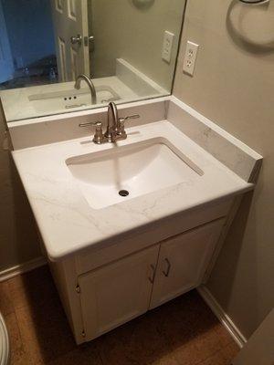 Calacatta Quartz, with square undermount sink provided by Best Granite. They removed and re-installed the mirror as part of demo cost.