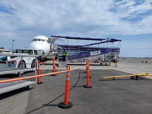 Walk up the ramp (in the sunshine) to board the plane!