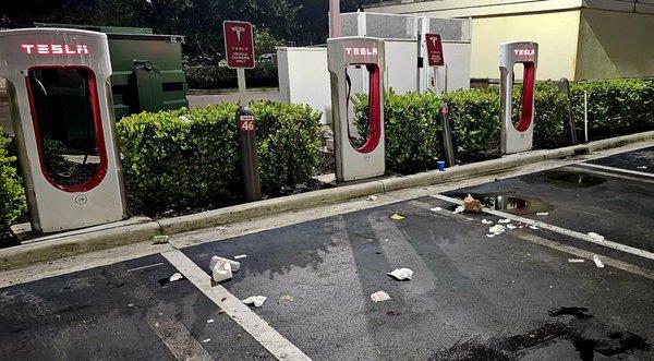 The Tesla Supercharger area is littered with trash, as there are no receptacles here and half the chargers are broken.