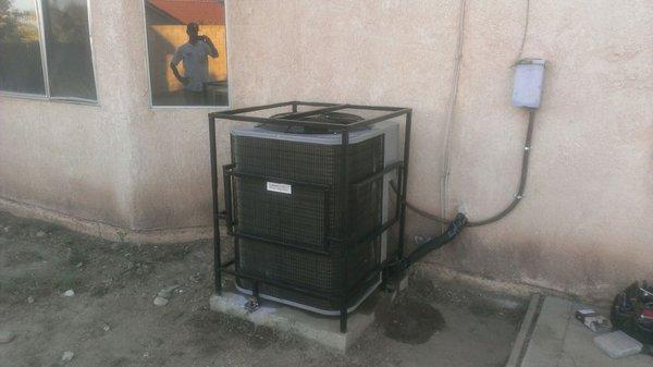 A/C unit with cage for vandalism or theft.