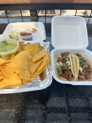 Carnitas tacos with chips and salsa.