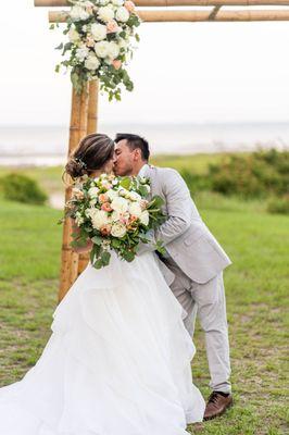 Bride and Groom in front of rustic arbor