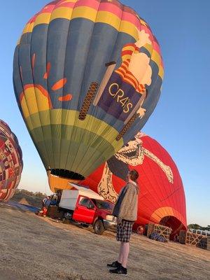 He's admiring how big the balloons are!