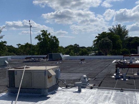 Aluminum coating in progress on a commercial roof