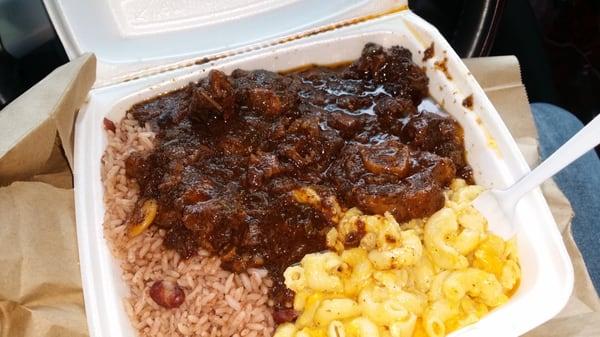 Oxtail with mac and cheese  and rice and peas..... had to dive in, inside the car lol