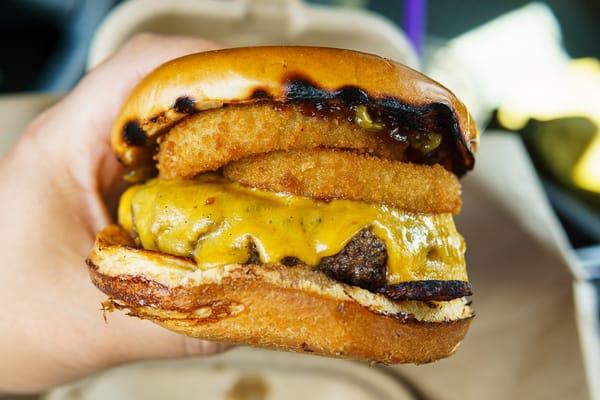 The Bacon Burger. From top to bottom: BBQ sauce, roasted jalapenos, onion rings, cheddar cheese, burger, bacon.