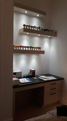 This is a fitted desk with floating shelves with l.e.d. spot lights