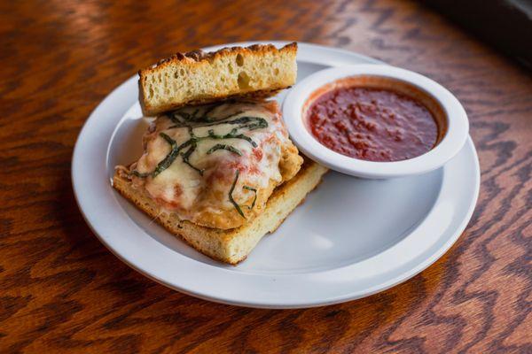 Chicken Parm Focaccia: Fresh chicken fried in our house parm-panko breading, topped with parmesan, provolone, our house marinara, and sliced