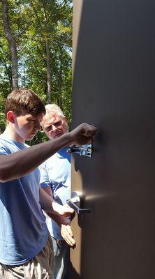 Slide bolt installation on metal door.