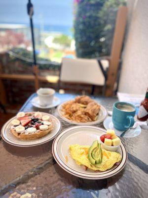 Mediterranean Sandwich, Belgian Waffle with fruit, Ocean View Omelet with ham,  Cappuccino, and  Americano