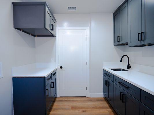 LAUNDRY ROOM, FOLDING AREA, EXTRA CABINETS FOR STORAGE.