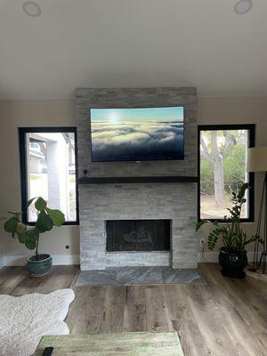 Changed from brick to stone on fire place, added mantel, hearth, and mounted TV.