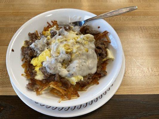 Sausage, cheese, scrambled egg, hash brown bowl with gravy.