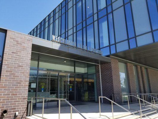 The lobby entrance doors are on the West side. There is free parking in a fairly narrow lot on the north side of the station.