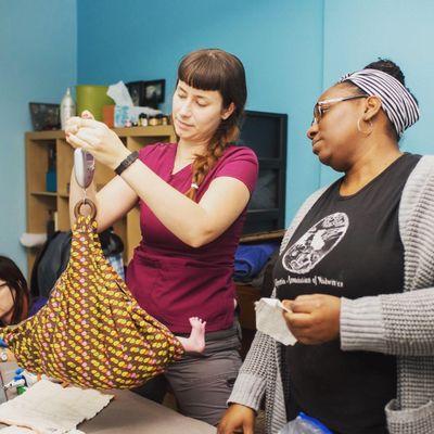 Weighing a newborn at a Homebirth. Doula and Student Midwife, Ceniza Reed and Darynee Blount LM, CPM