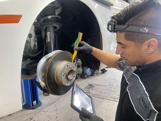 Our technician is ensuring proper brake wear and rotor condition on this 2013 bmw 328i. He is inspecting both front and rear brake pads