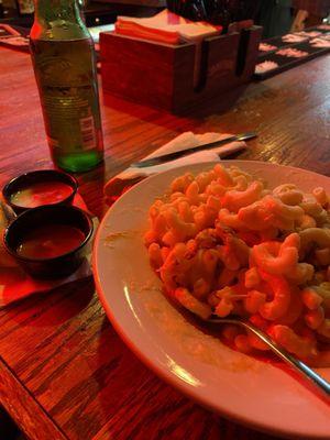 Mac and cheese with chicken, and sides of hot sauce and bleu cheese with a Heineken.