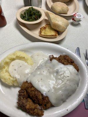 Chicken fried steak, mashed potatoes, cream gravy, green beans, and garlic bread