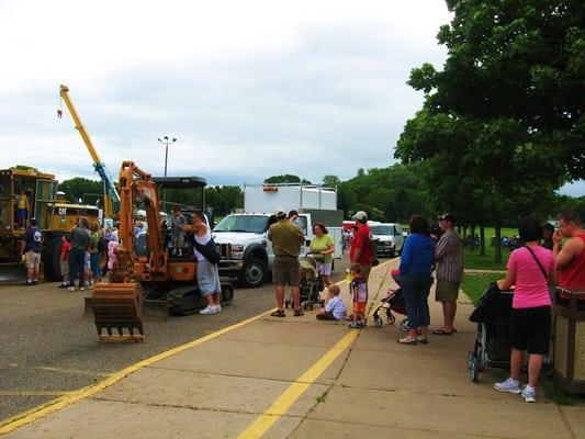 People wait in line to see the Steiner's mini excavator and utility truck at the Touch-A_Truck event held in River Falls, WI.