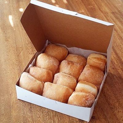 Dozen Malasadas in a box, can be filled with Bavarian Cream, Chocolate and Haupia