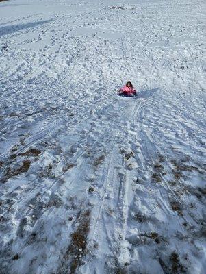 Sledding and tubing down to the soccer field at Evans Park