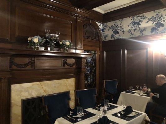 Side dining room with French finish wainscoting, silk wallpaper and Tiffany fixtures.