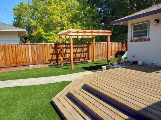 Synthetic lawn project, built pergola, laid pavers for path through yard.