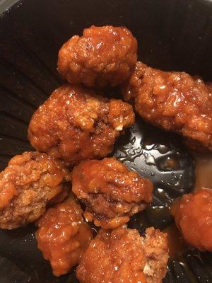 Burnt boneless wings that were dipped in sauce in attempts to cover it up