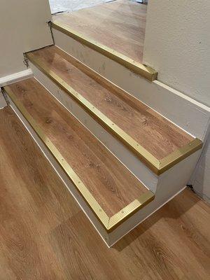 LVP installed on steps and floor to this entrance, love the gold accent bullnose!