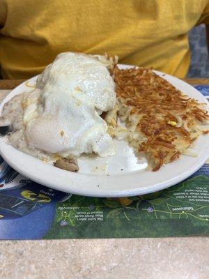 Chicken with sausage gravy and 2 eggs on top