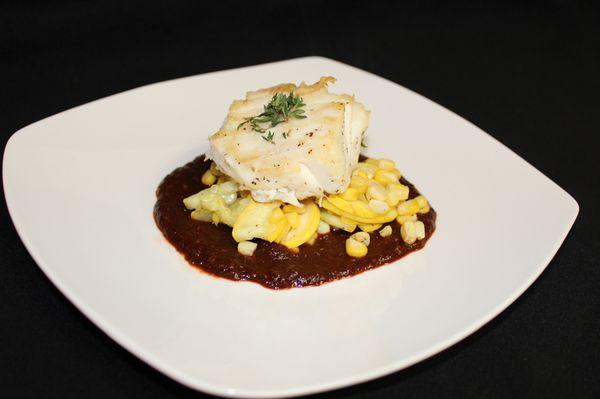 Roasted halibut with a squash and corn medley and molé sauce