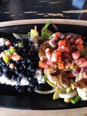 Tequila lime chicken with fresh pico de gallo on a bed of fresh veggies with rice & beans.