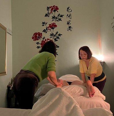 Massage therapists massaging a client.