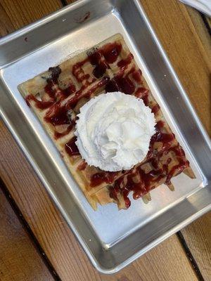 Chocolate stuffed waffle with strawberry jam and whipped cream